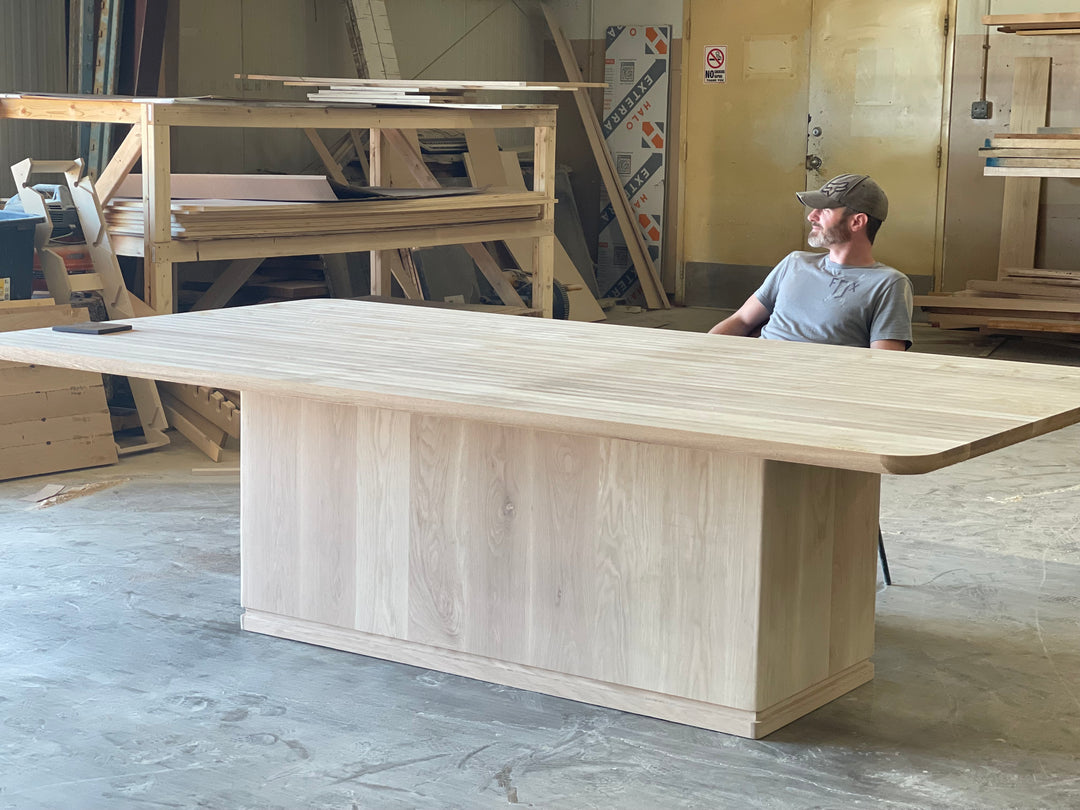 Solid wood Westlake dining table with clean rectangular lines, shown unfinished set in a workshop