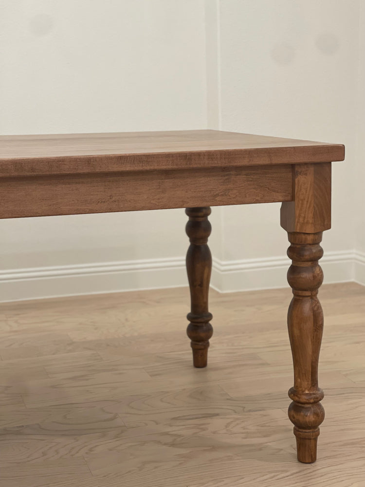 close up view of the special walnut-stained maple rectangular dining table with four pedestal legs, showcasing rich color and elegant craftsmanship.