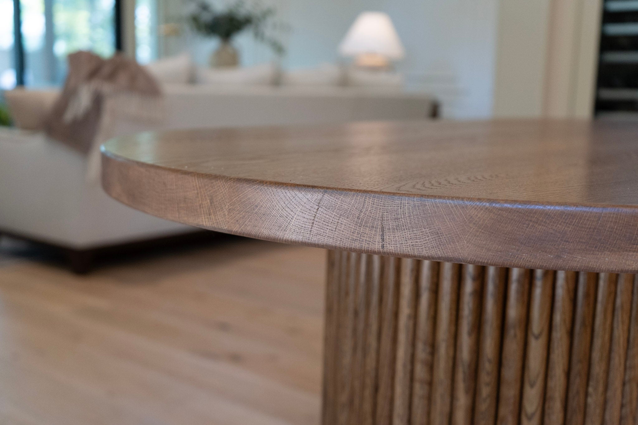 Close-up of a wooden dining table with a blurred background