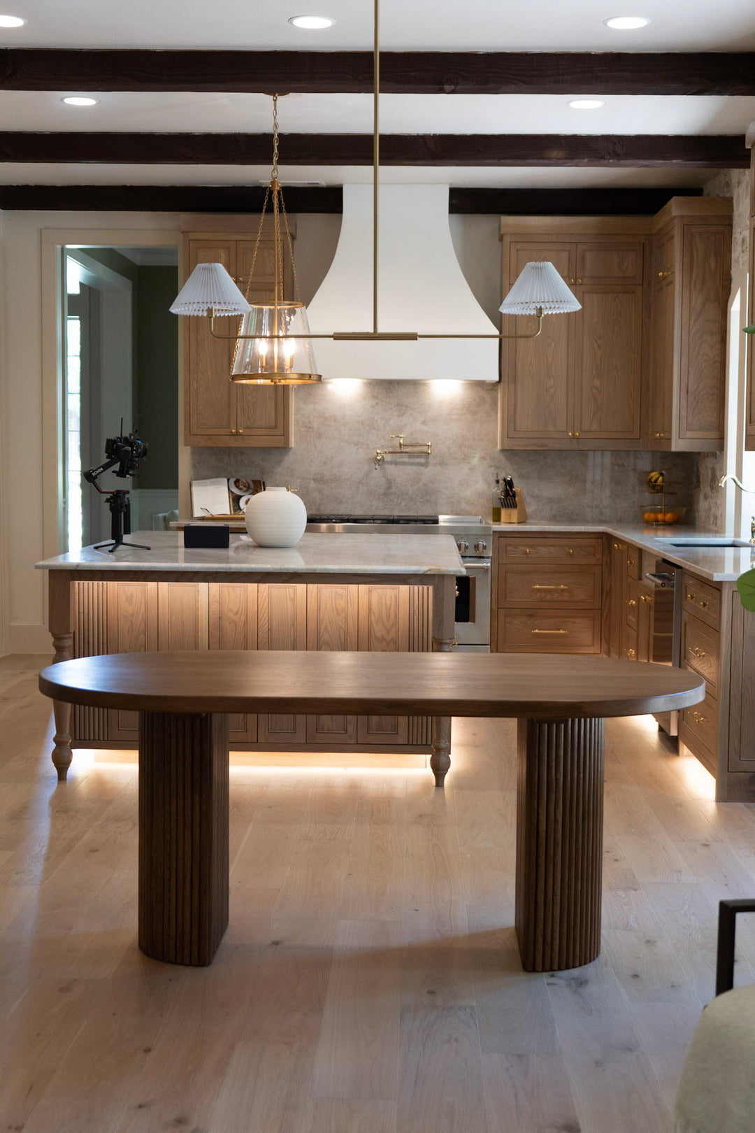 Modern fluted white oak dining table with oval top and half-cylinder base