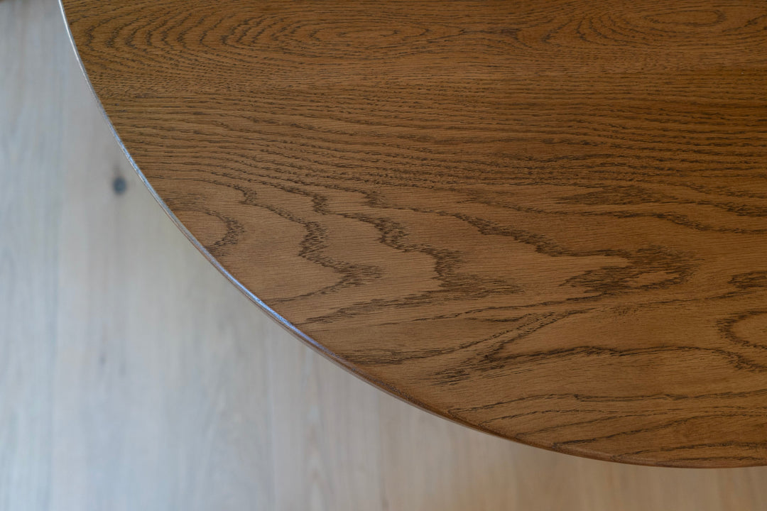 Close-up of a wooden table surface with a light background