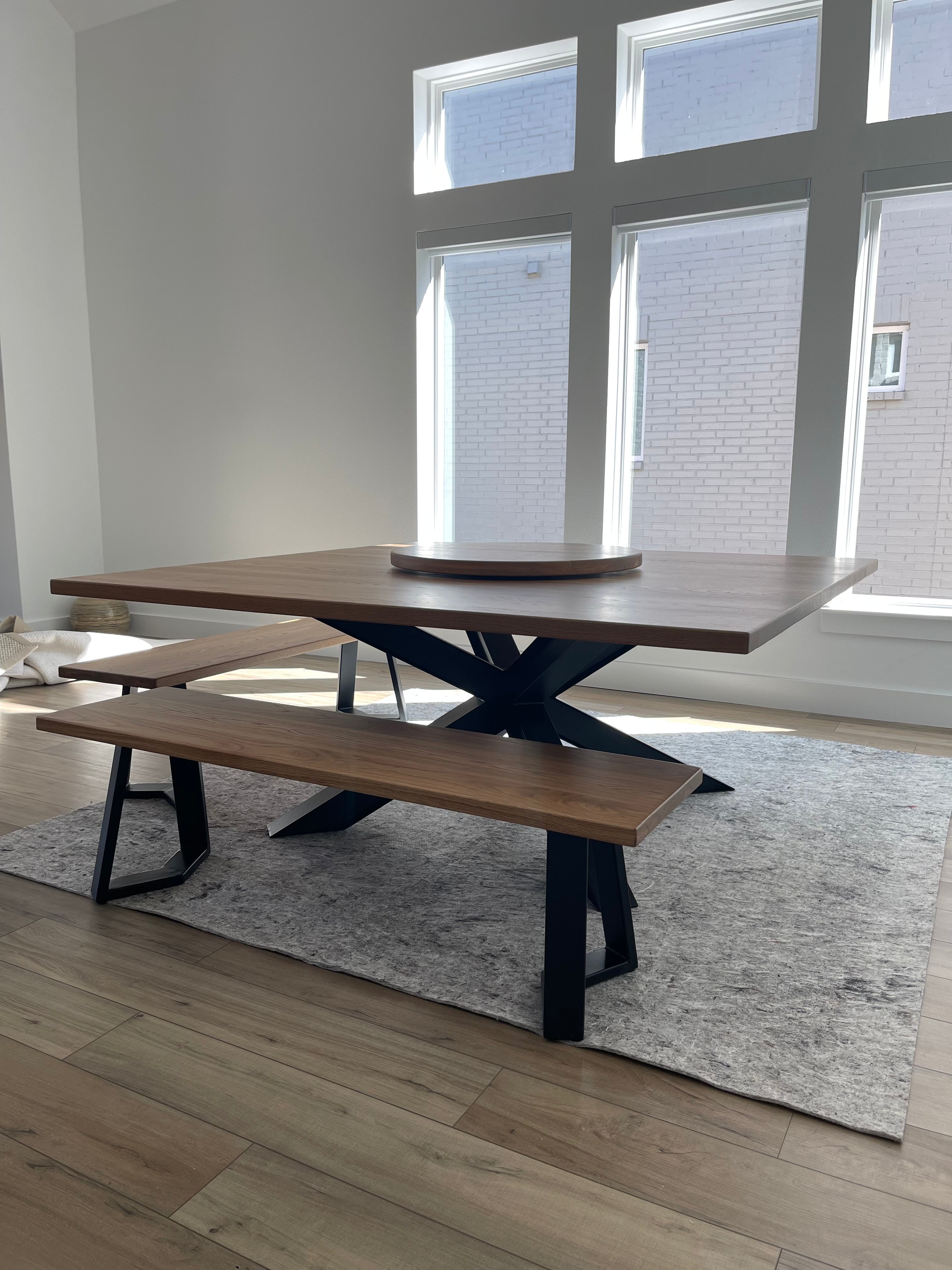 Large square metal dining table paired with two matching metal benches, creating a modern and industrial look.