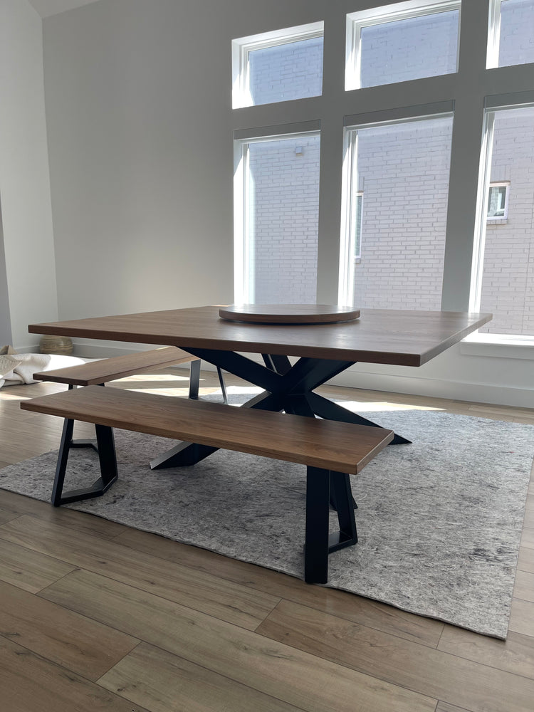 Large square metal dining table paired with two matching metal benches, creating a modern and industrial look.
