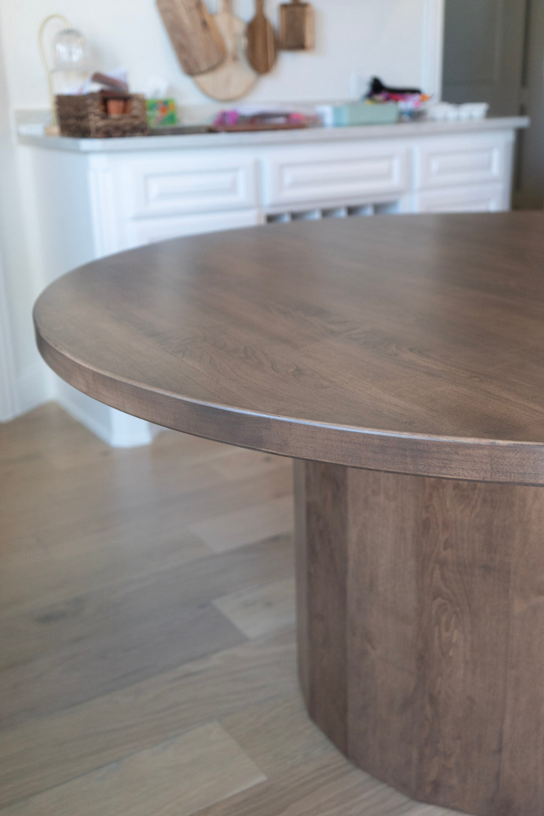 Wooden dining table in a room with a white fireplace and decorative items.