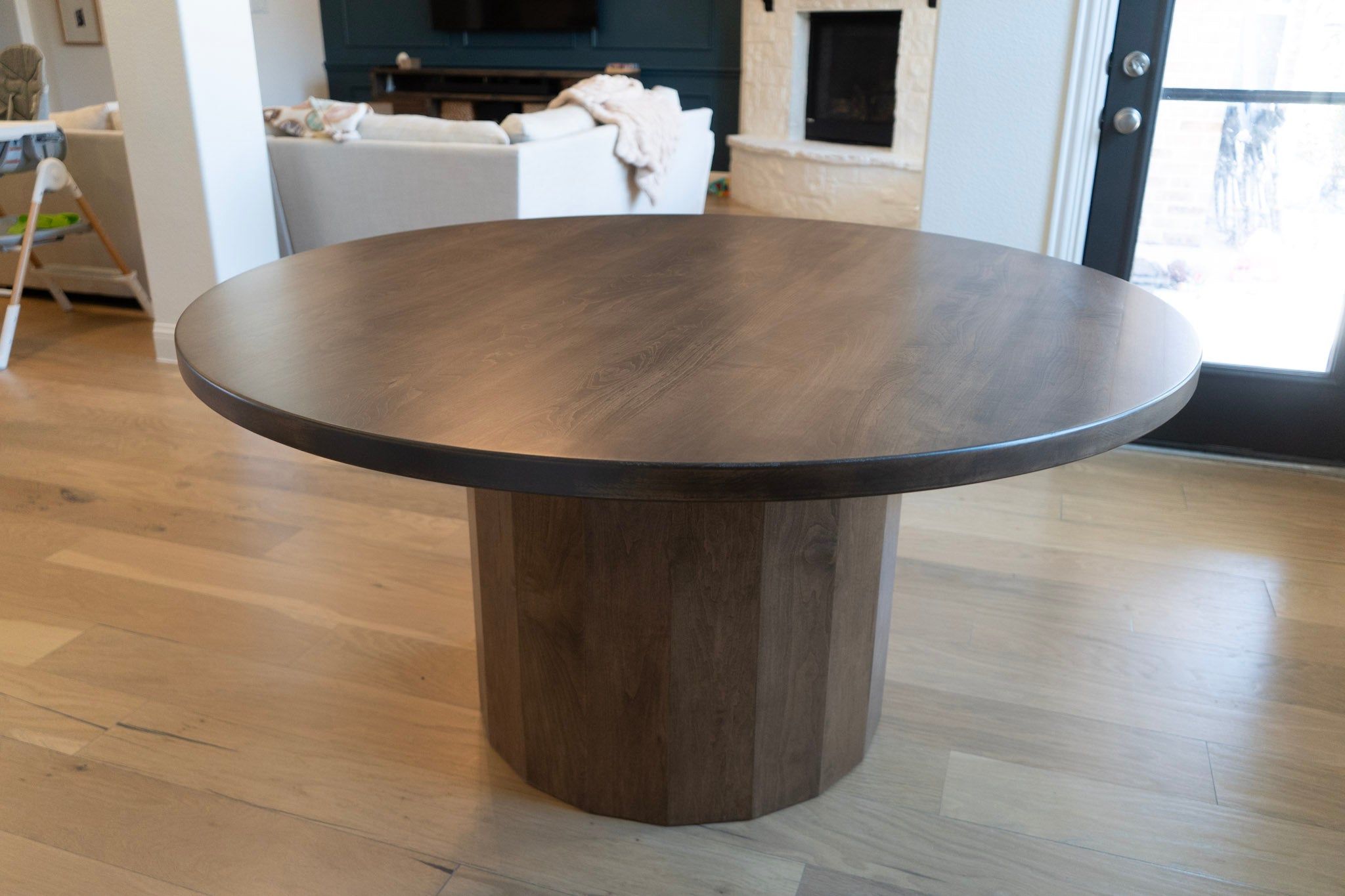 Round wooden dining table in a living room setting