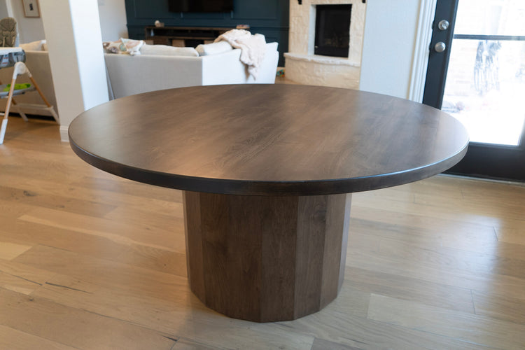 Round wooden dining table in a living room setting
