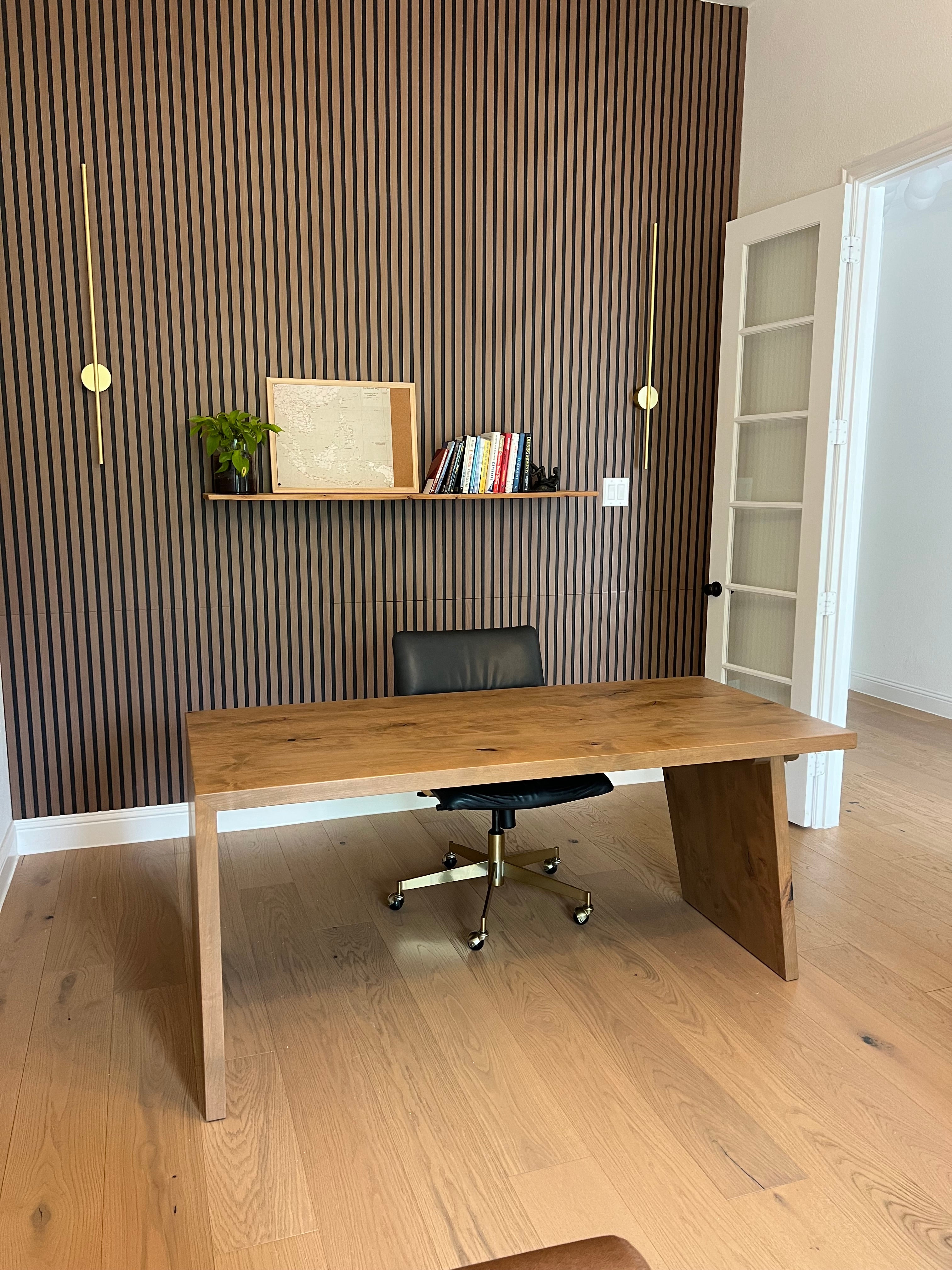 Wooden desk with chair in a room with fluted wall