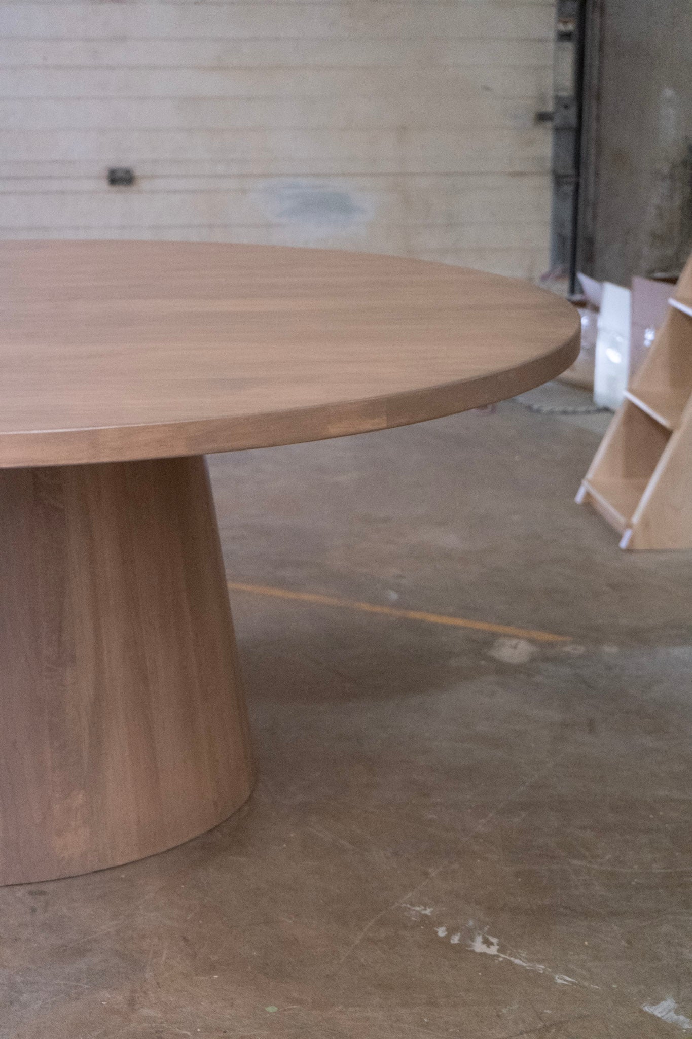 Wooden cone dining table in a warehouse setting