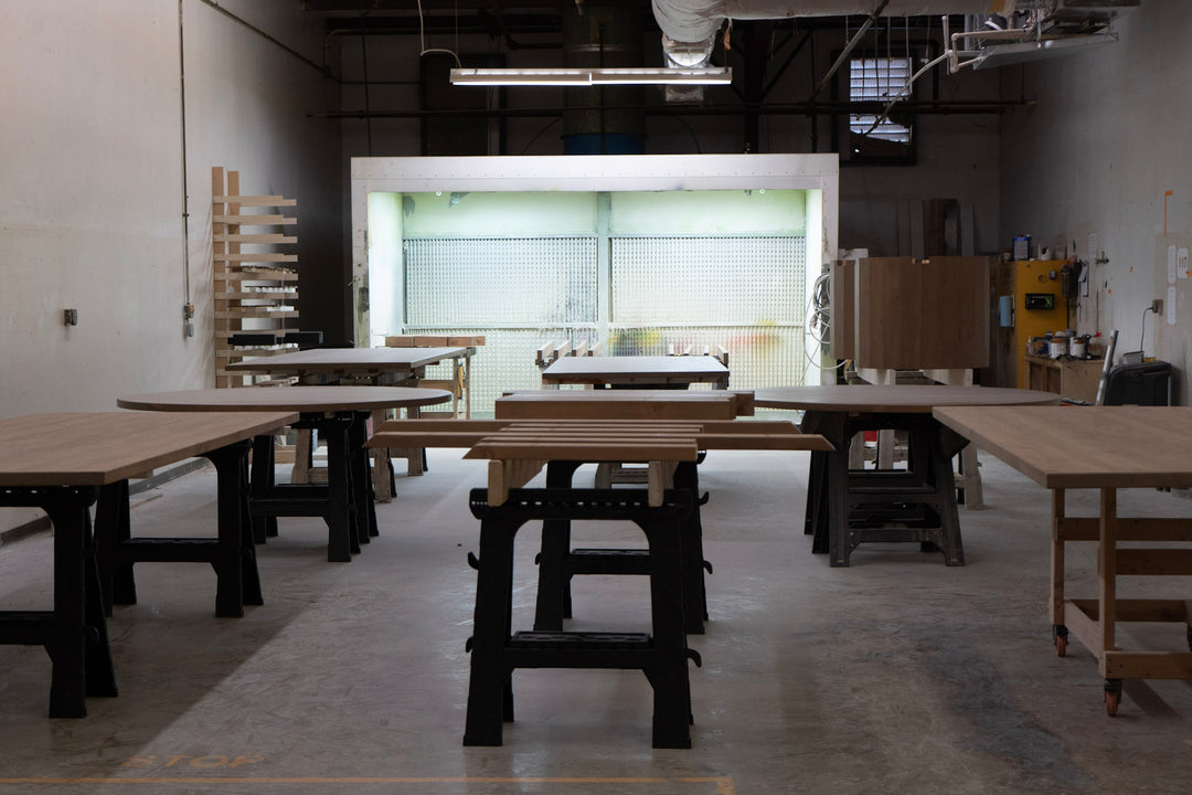 Large room with wooden tables in a workshop setting