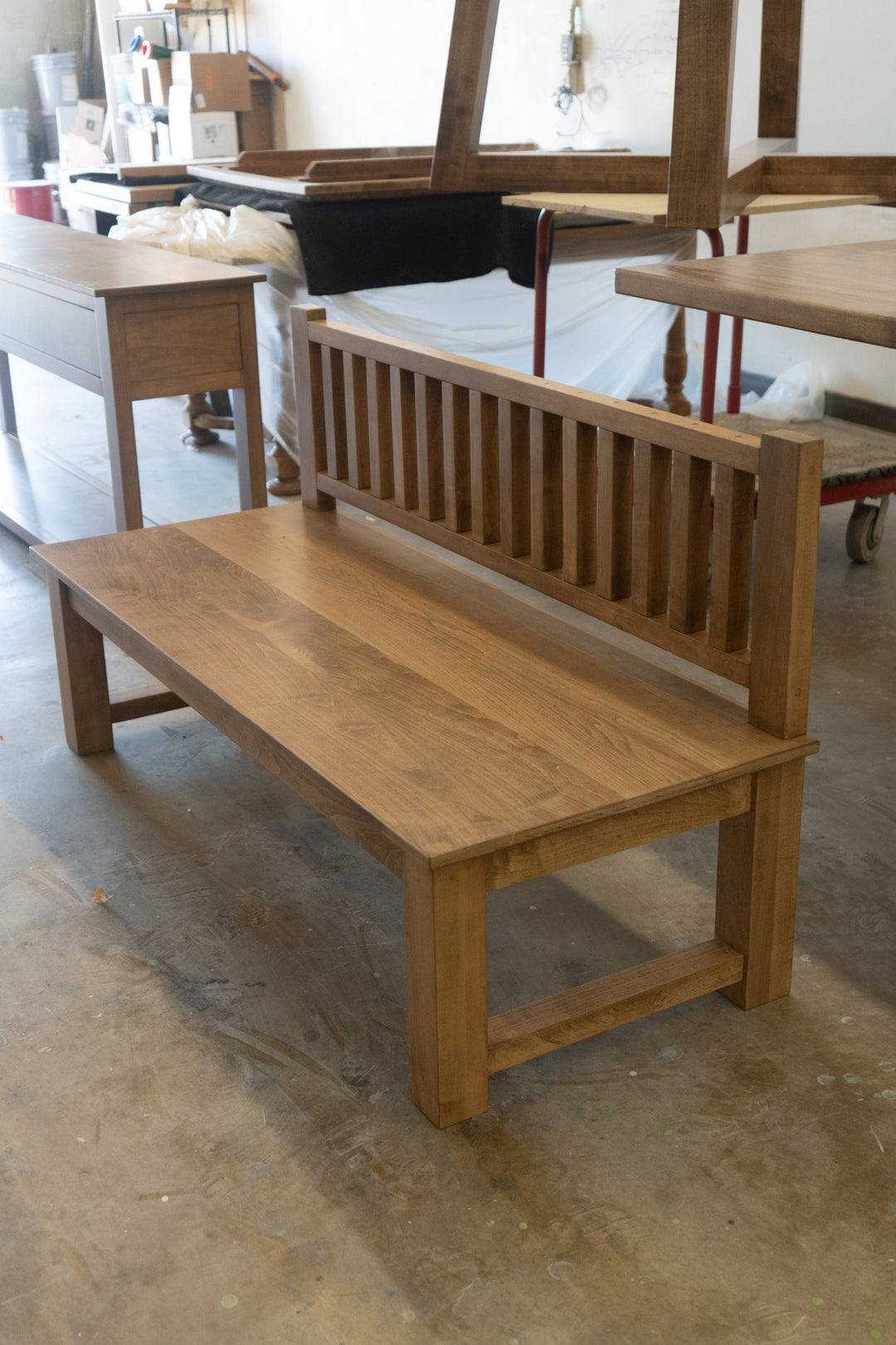 Wooden bench in a workshop setting with tools and materials in the background