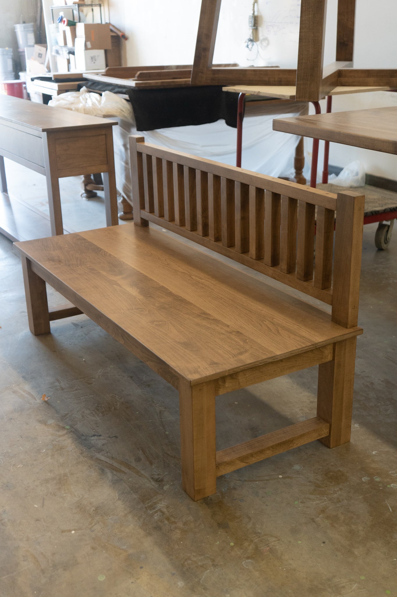 Wooden bench in a workshop setting with tools and materials in the background